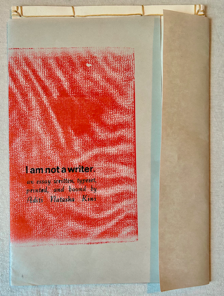 Sheath of book featuring a bright orange riso print and letterpress type saying "I am not a writer"